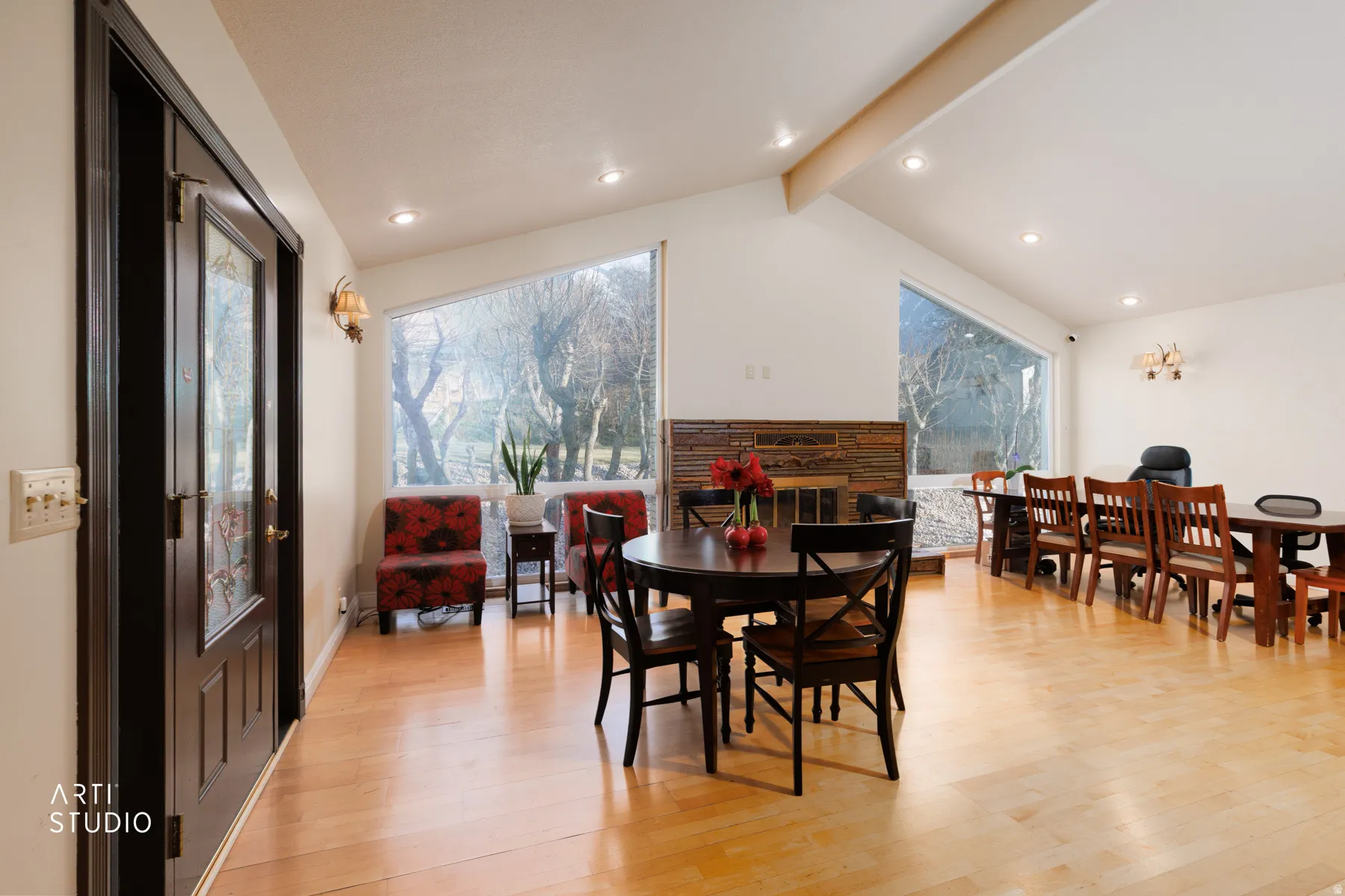 Dining area featuring a glass covered fireplace, light wood-style flooring, recessed lighting, beamed ceiling, and healthy amount of natural light