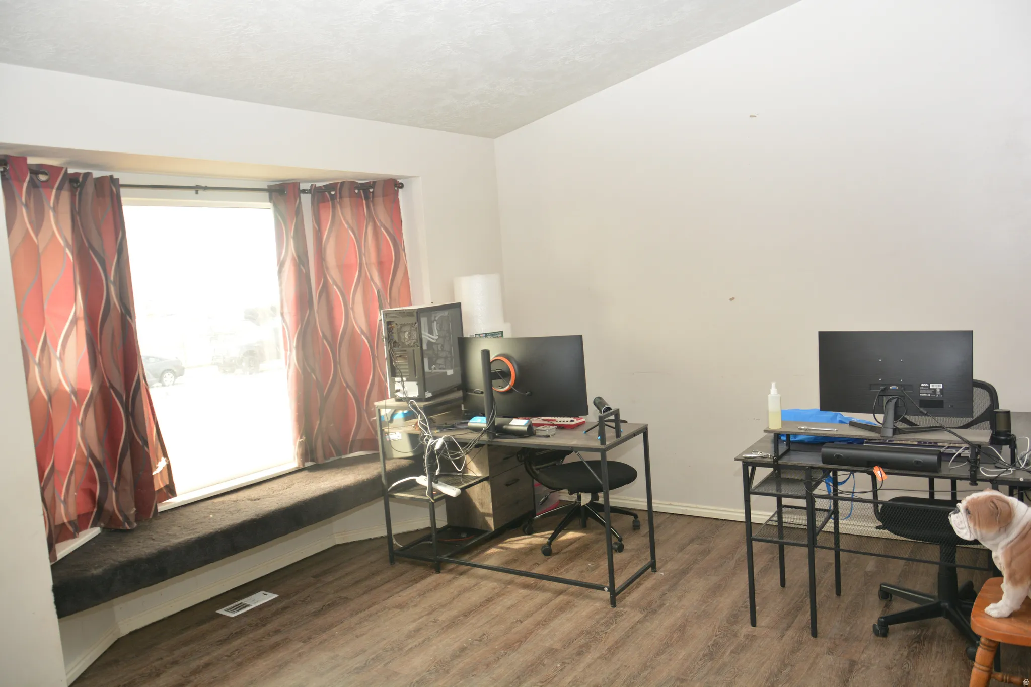 Home office with dark wood finished floors and a textured ceiling
