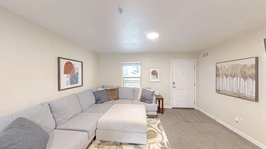 Living room featuring baseboards and light carpet