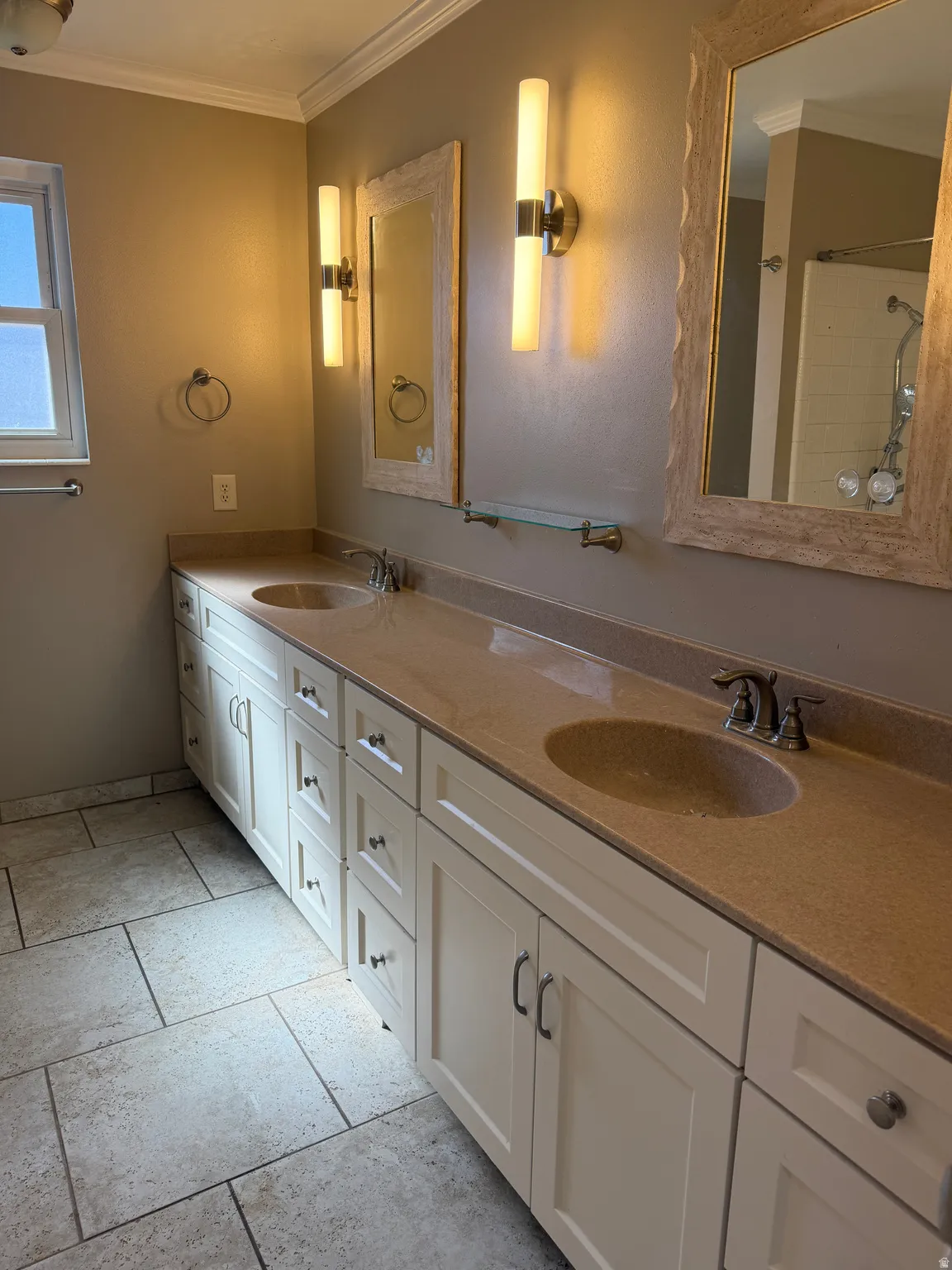 Full bath featuring crown molding, double vanity, and a shower
