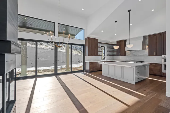 Dual tone kitchen with dual tone cabinetry, a kitchen island, backsplash, dark wood finished floors, and open shelves