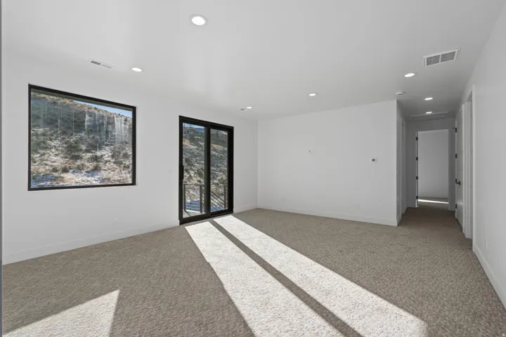 Upper level family room with light colored carpet and recessed lighting