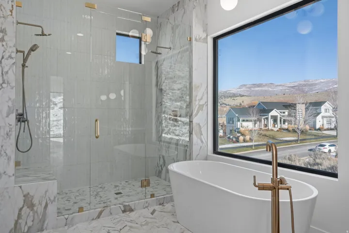 Primary Bathroom with a freestanding bath, a shower stall, and a mountain view
