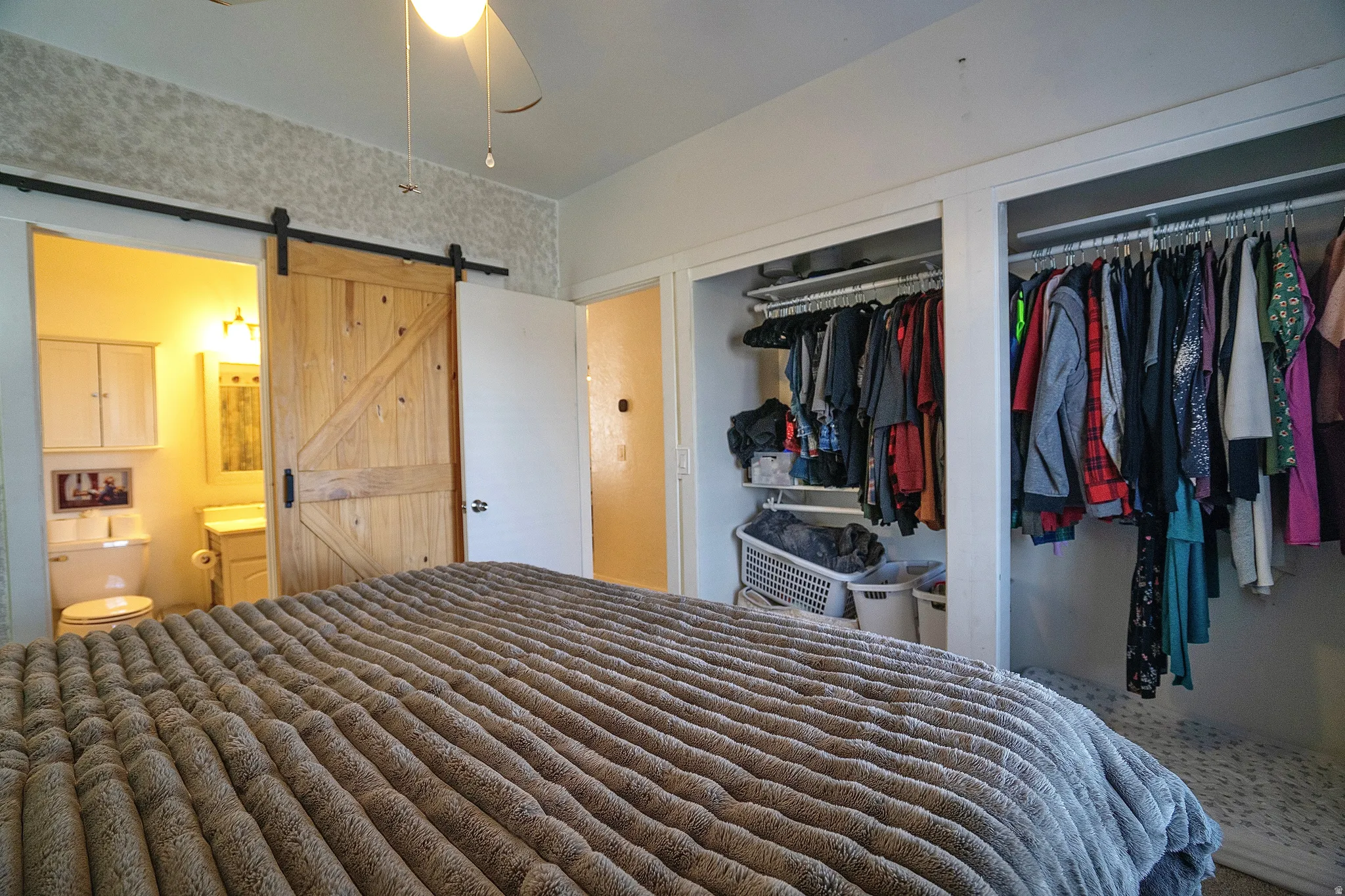 Bedroom with a barn door and multiple closets
