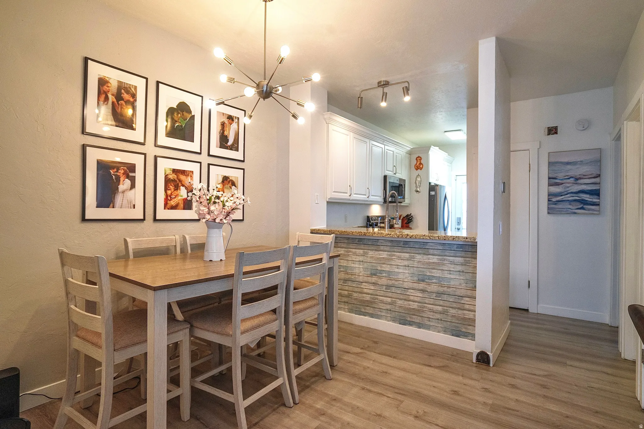 Dining area with hanging lights and light wood-type flooring