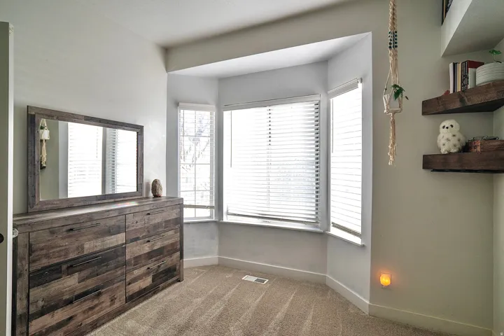 Bedroom featuring dark colored carpet and baseboards