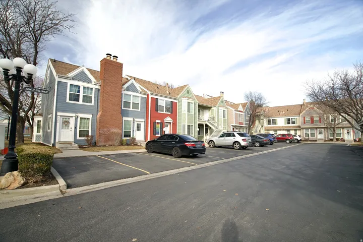 View of front facade featuring a residential view, uncovered parking, and a chimney