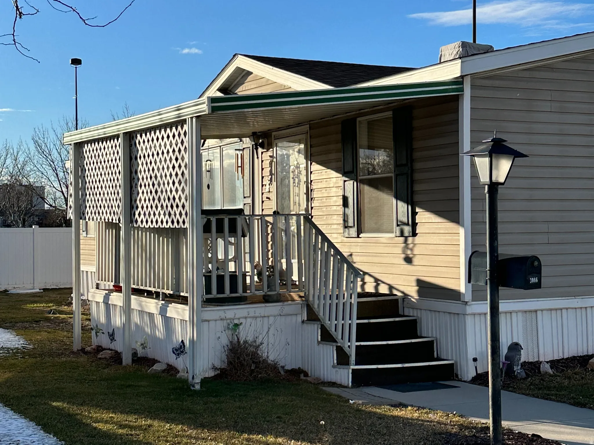 Manufactured / mobile home with a front yard and a porch