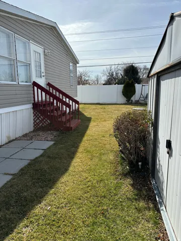 Fenced backyard featuring a storage shed