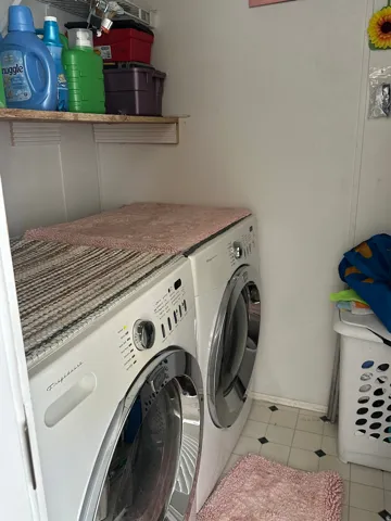 Laundry area featuring washing machine and dryer and light tile patterned flooring