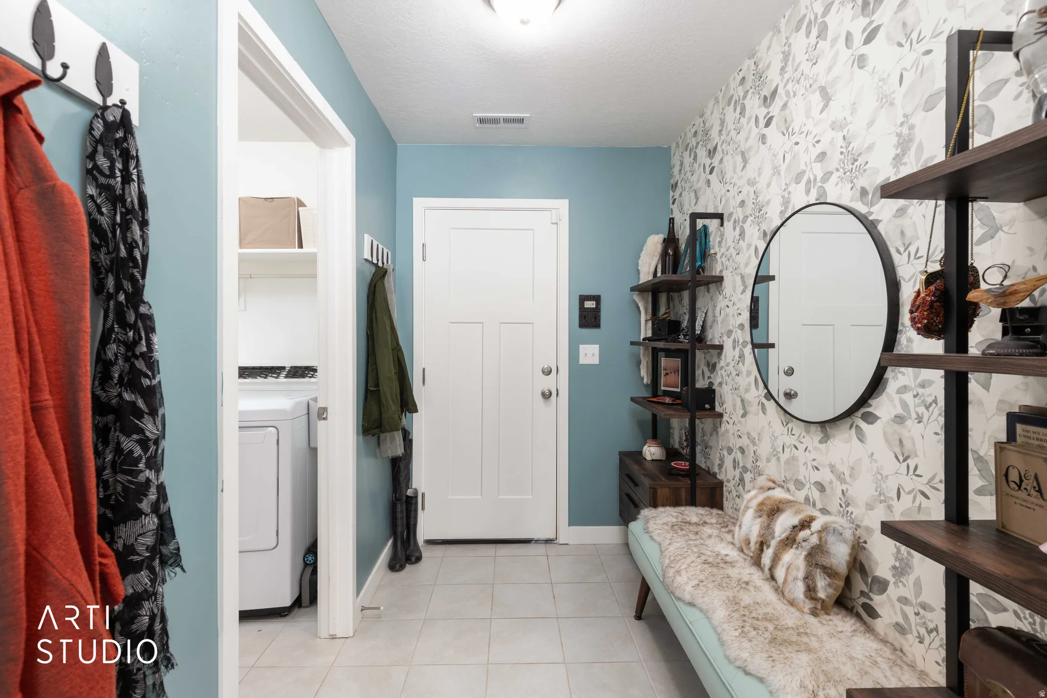 Entrance foyer with washer / dryer, light tile patterned floors, and wallpapered walls