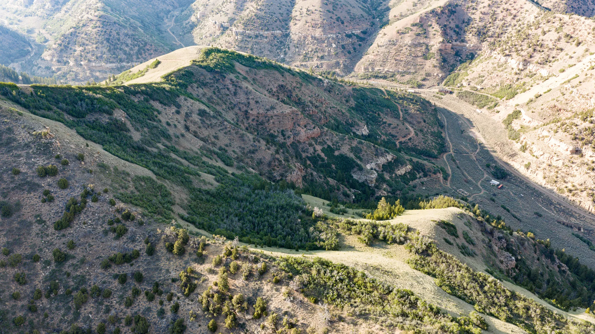 Mountainous terrain with natural vegetation and distant structures