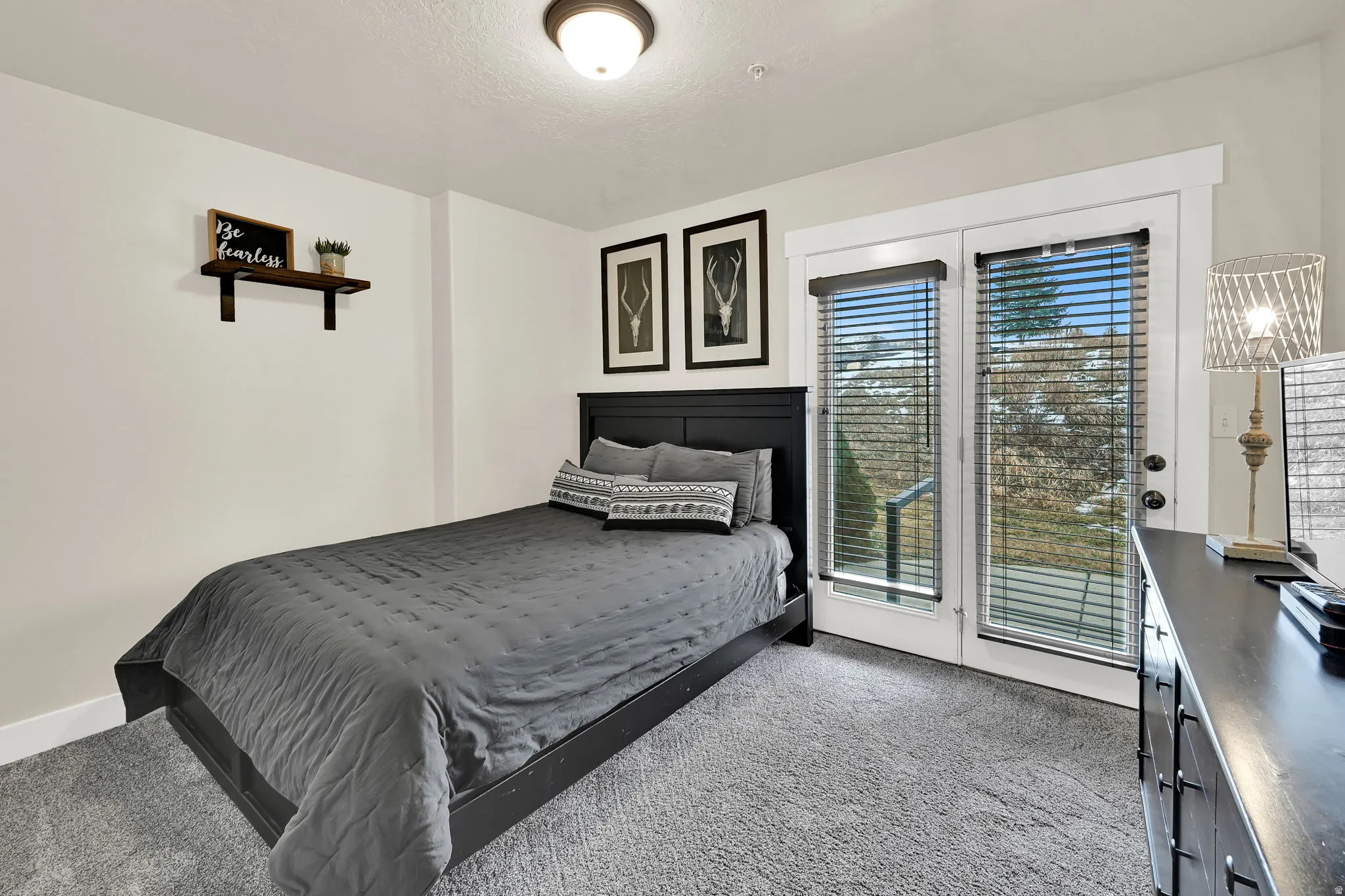 Bedroom with light colored carpet and access to exterior patio