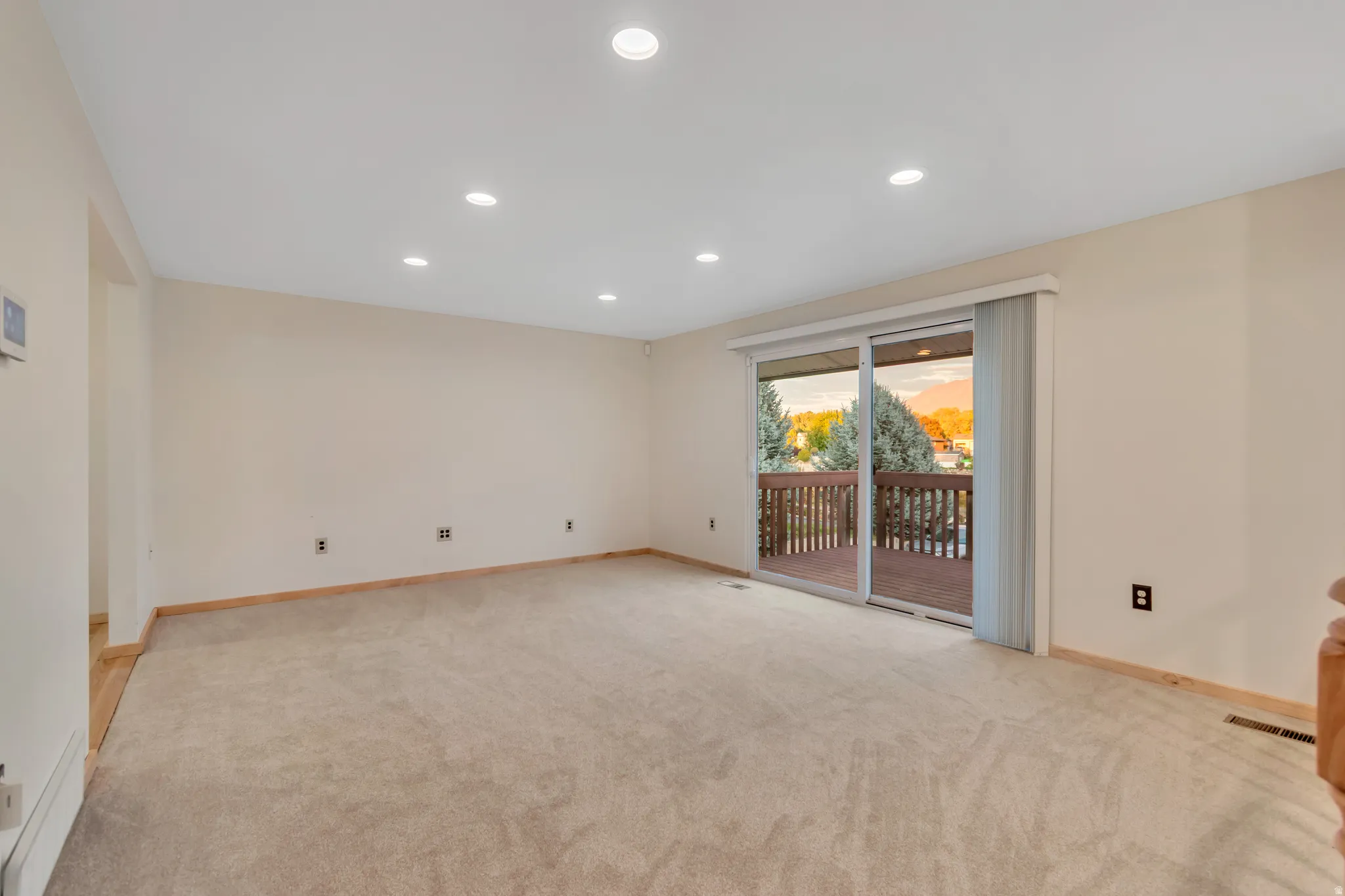 Empty room with recessed lighting and light colored carpet