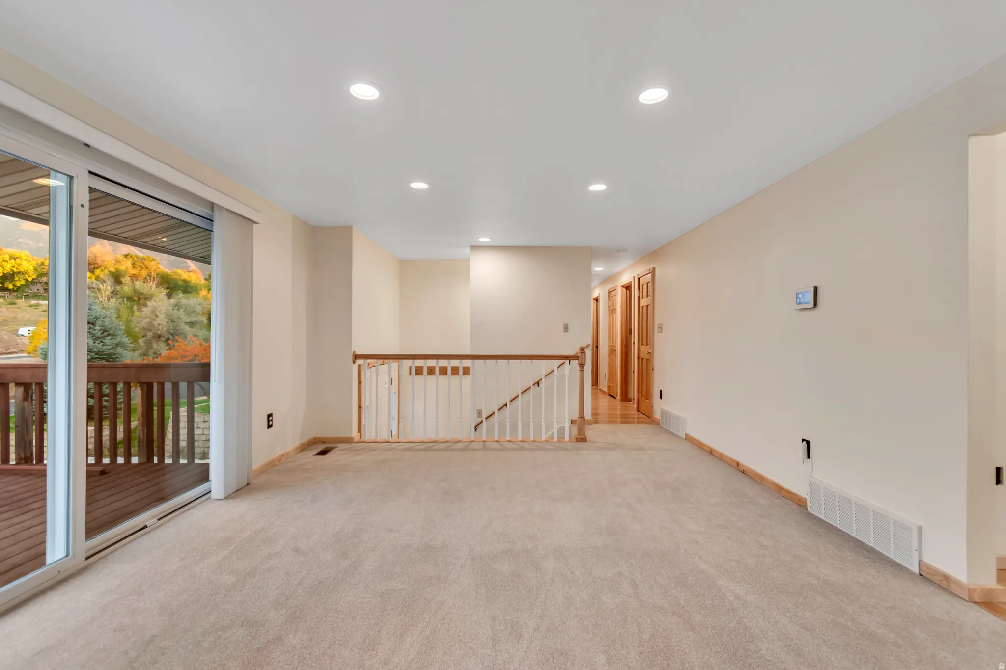 Empty room with recessed lighting and light carpet