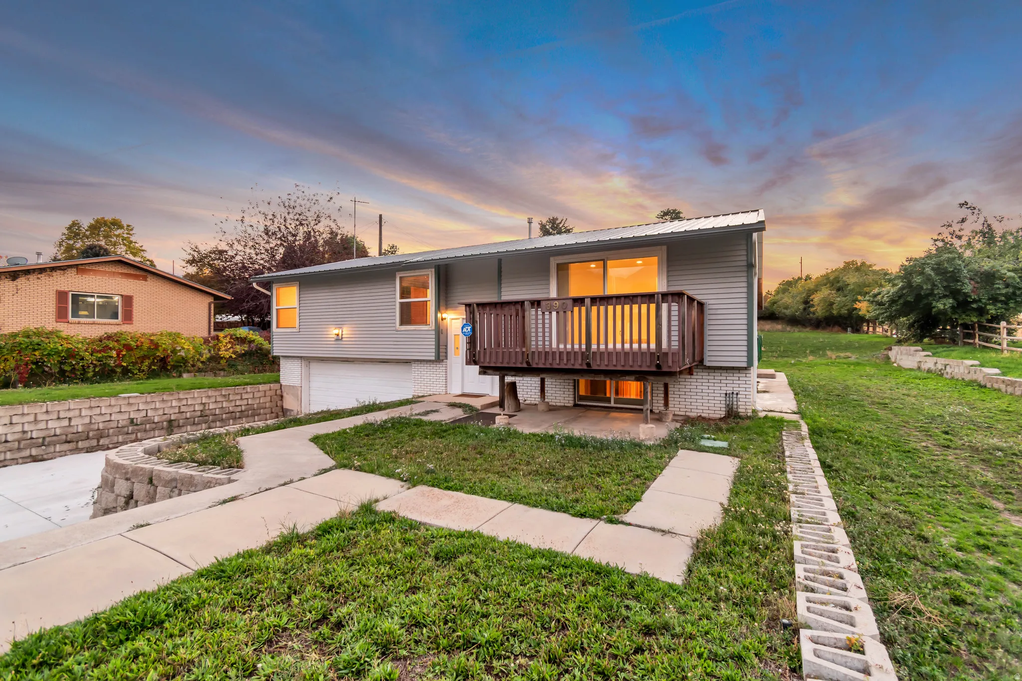 View of front of home featuring a garage, a lawn, and a metal roof