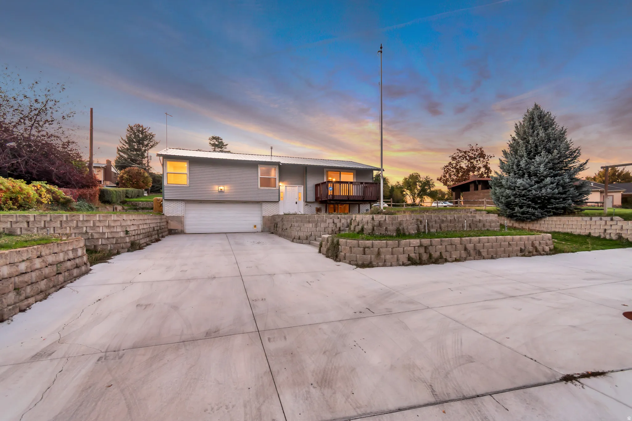Split foyer home featuring an attached garage, concrete driveway, and a balcony