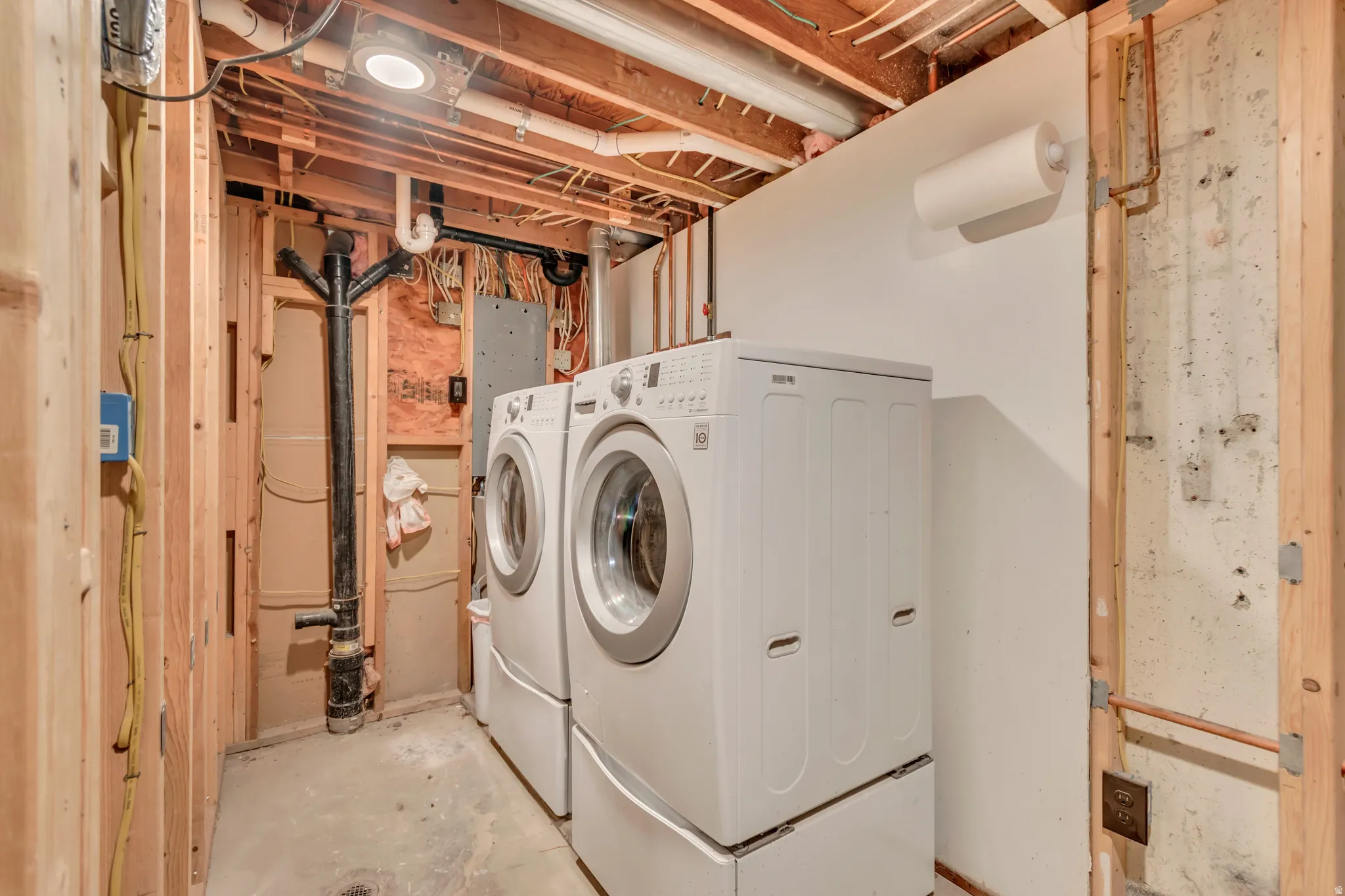 Laundry area with washer and dryer and concrete floors