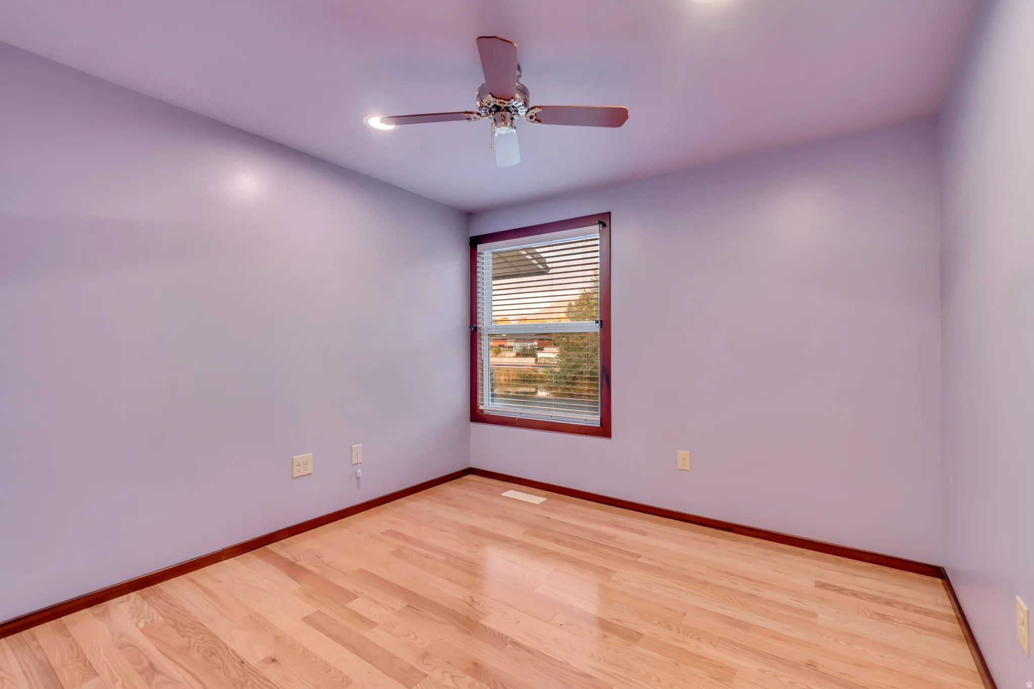 Spare room featuring light wood-type flooring, a ceiling fan, and recessed lighting