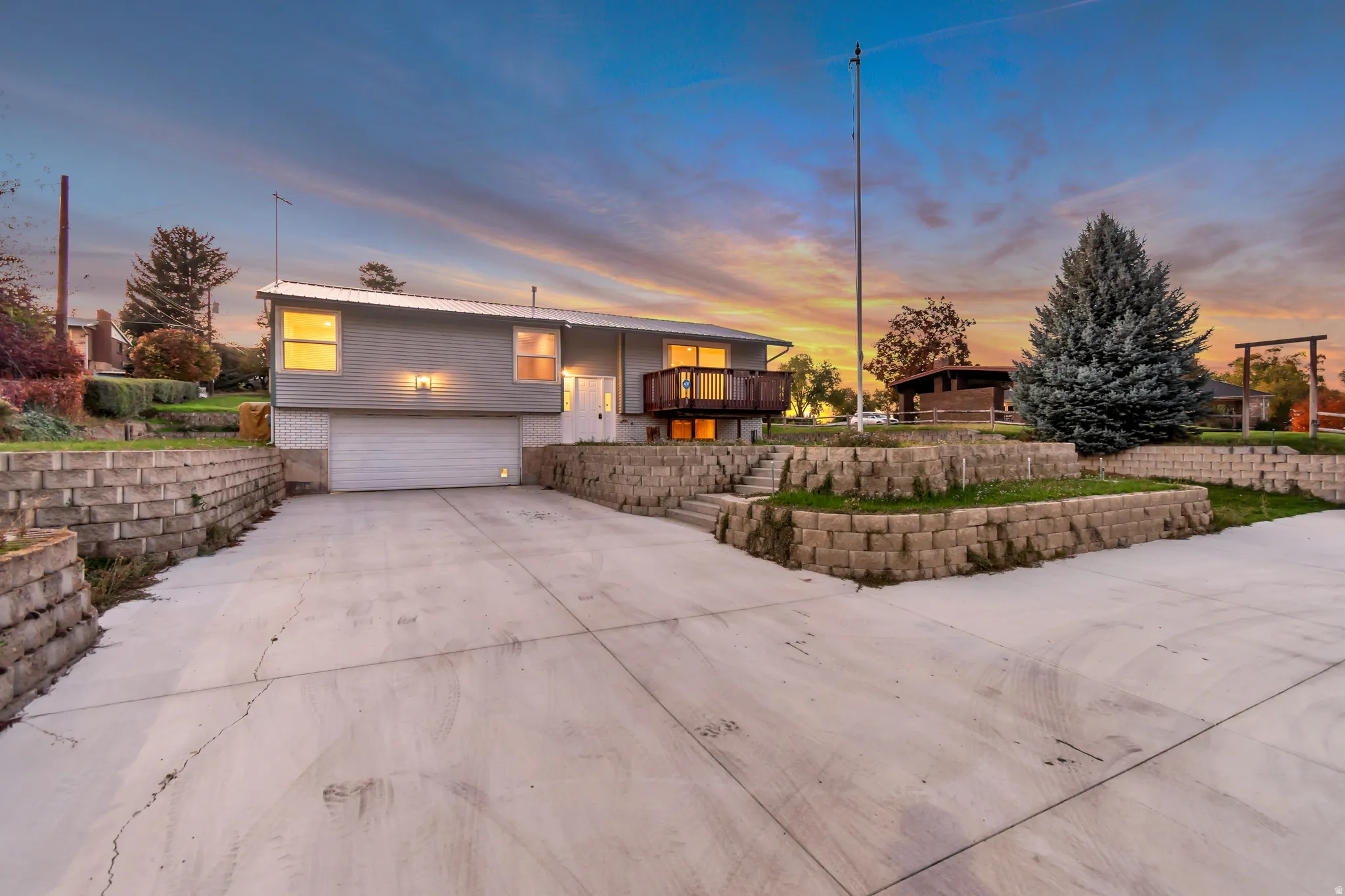 Bi-level home with an attached garage, concrete driveway, and a balcony