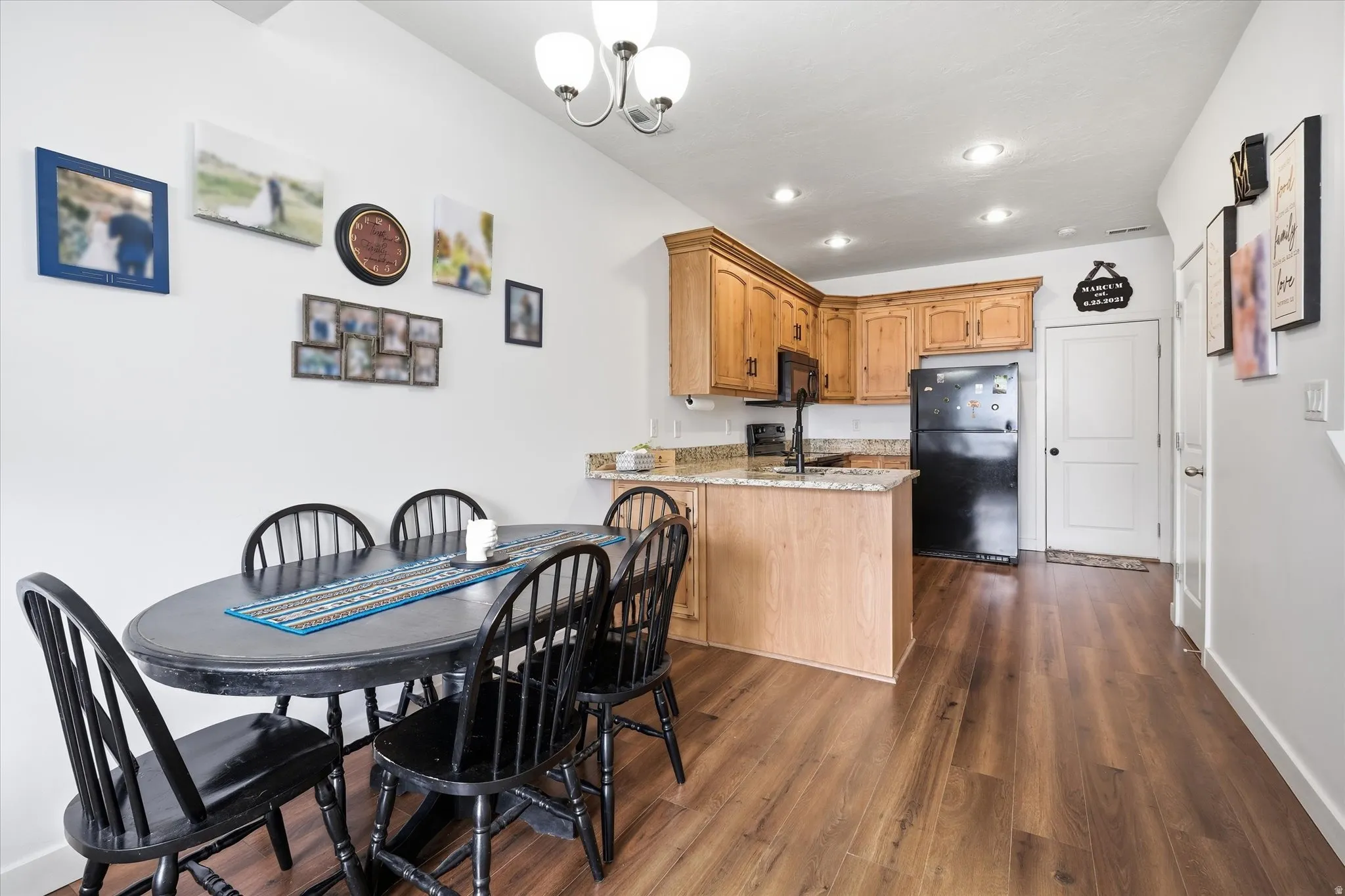 Dining room featuring dark wood-style flooring and hanging lights
