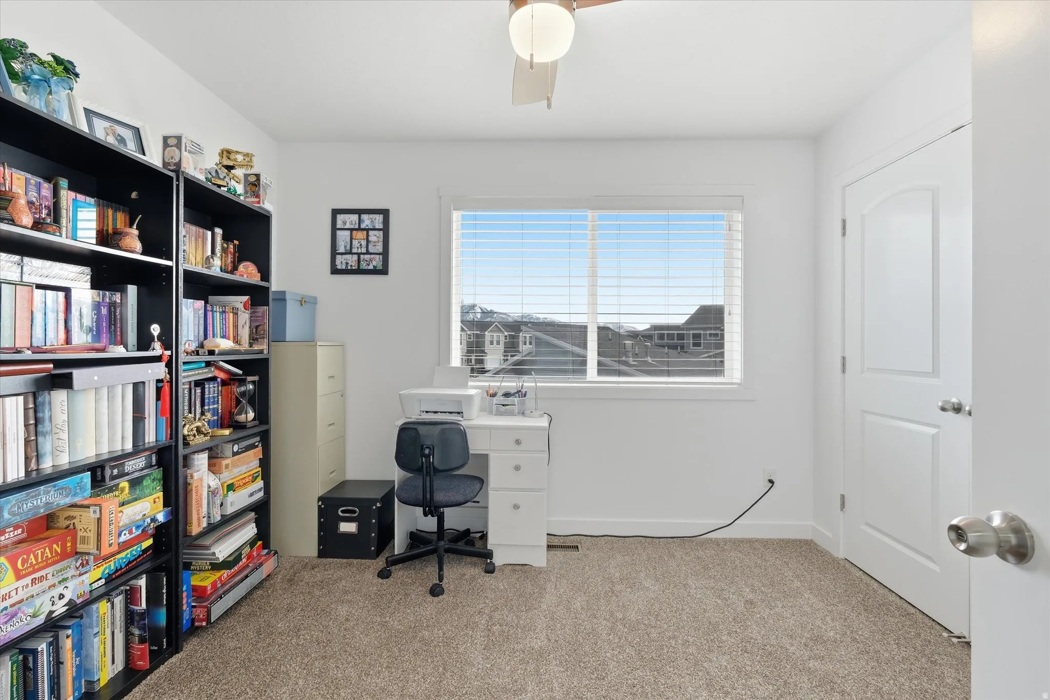 Office area with light carpet and ceiling fan