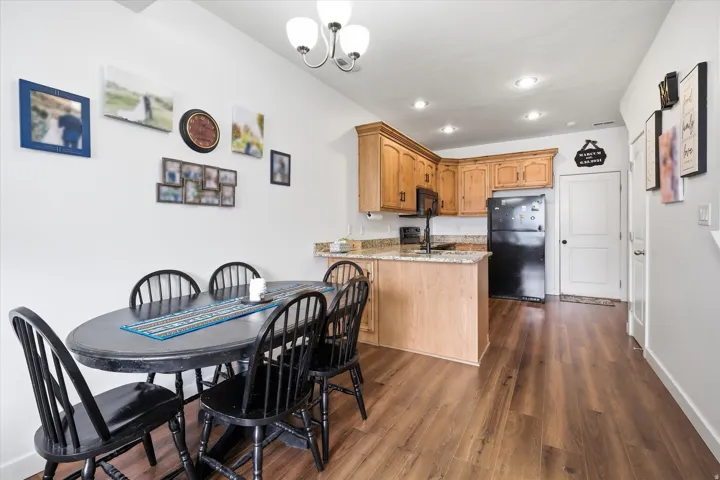 Dining room featuring dark wood-style flooring and hanging lights