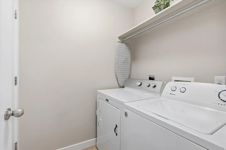 Laundry room featuring baseboards and washing machine and dryer