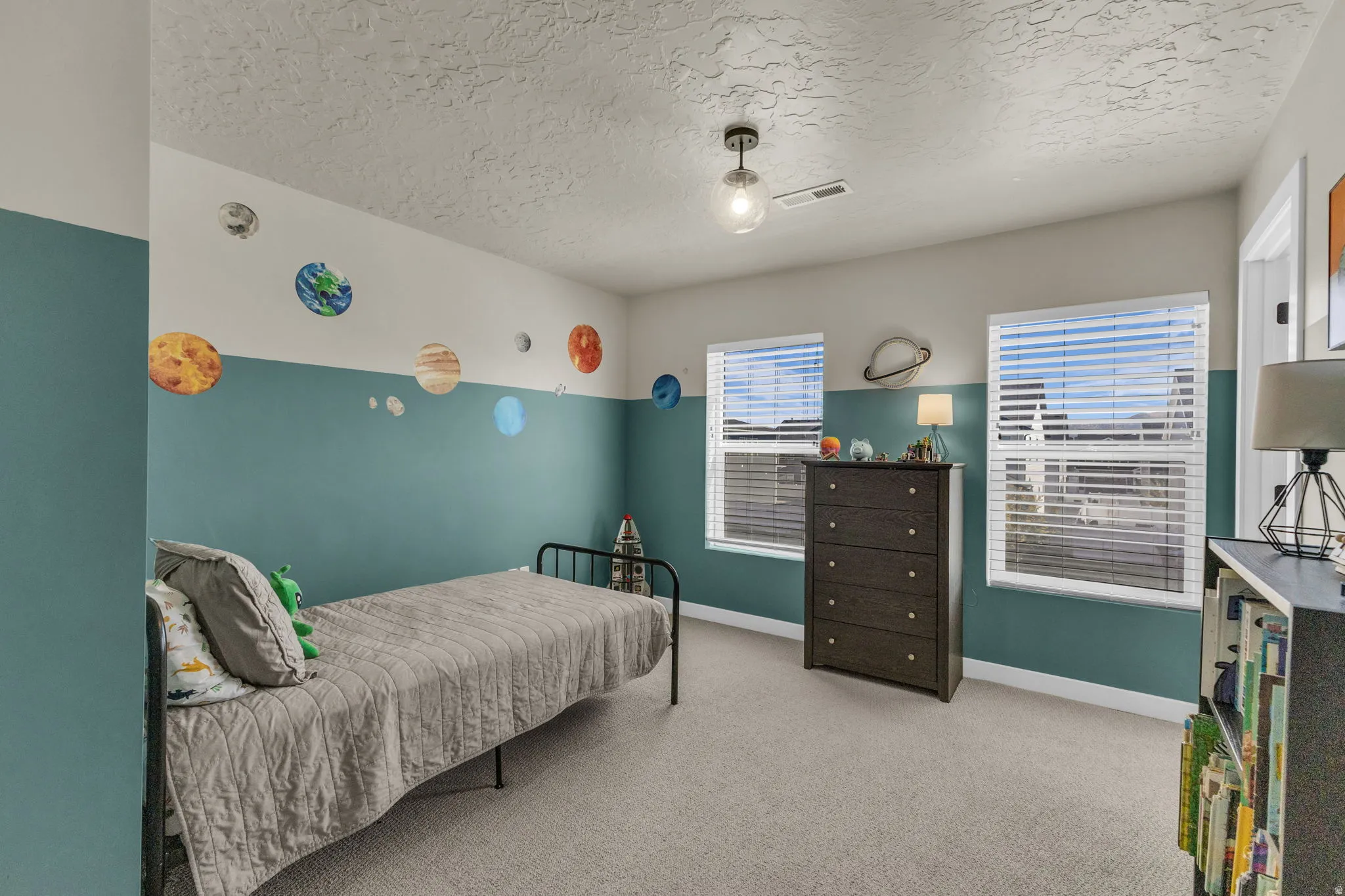 Bedroom featuring light colored carpet and a textured ceiling