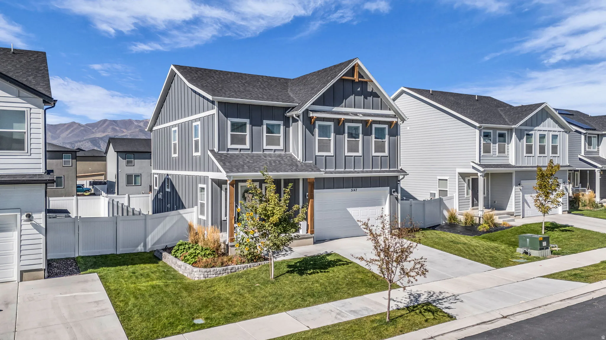 View of front of house with board and batten siding, a residential view, roof with shingles, an attached garage, and driveway