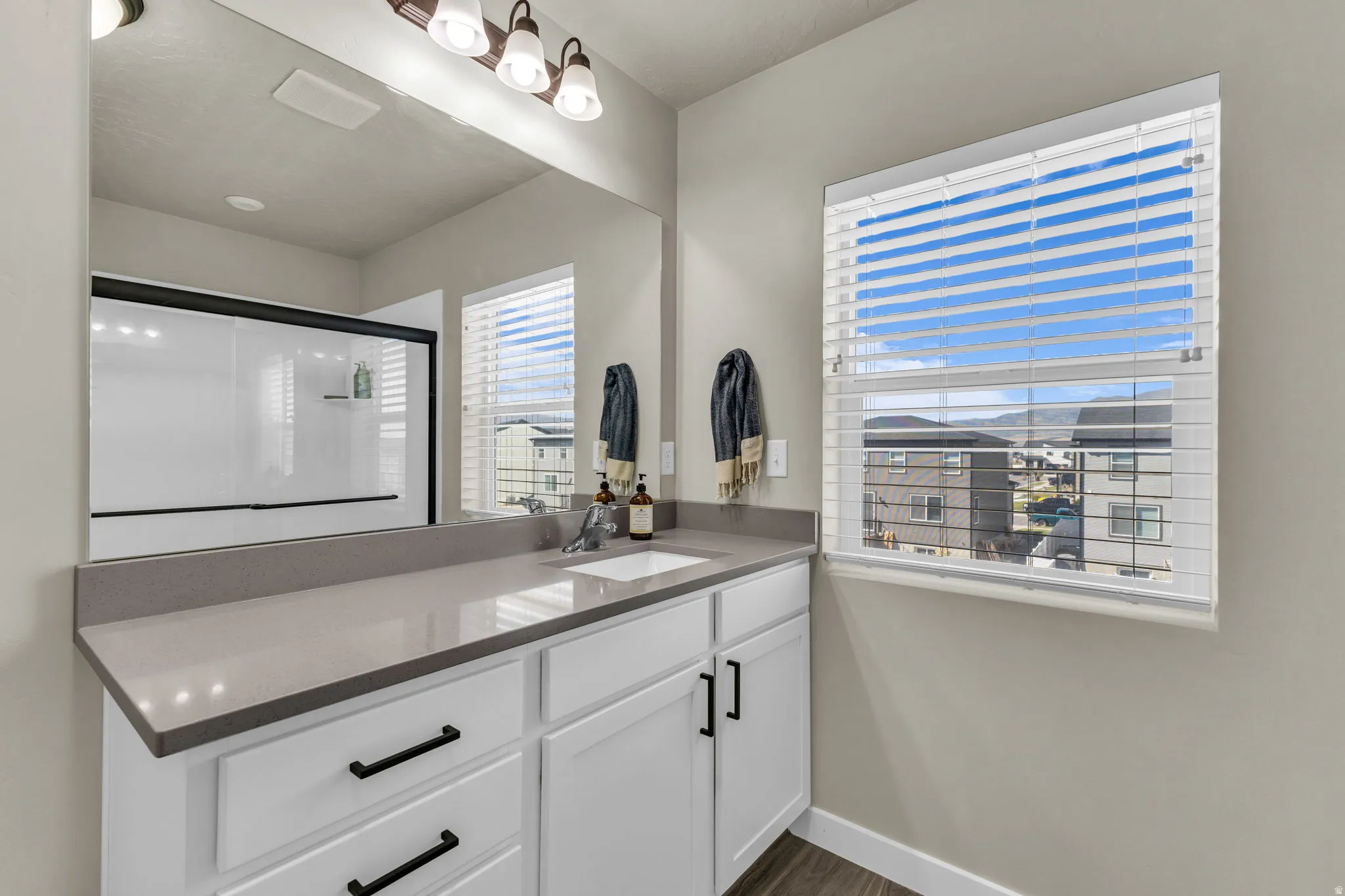 Full bath featuring vanity, a stall shower, and dark wood finished floors