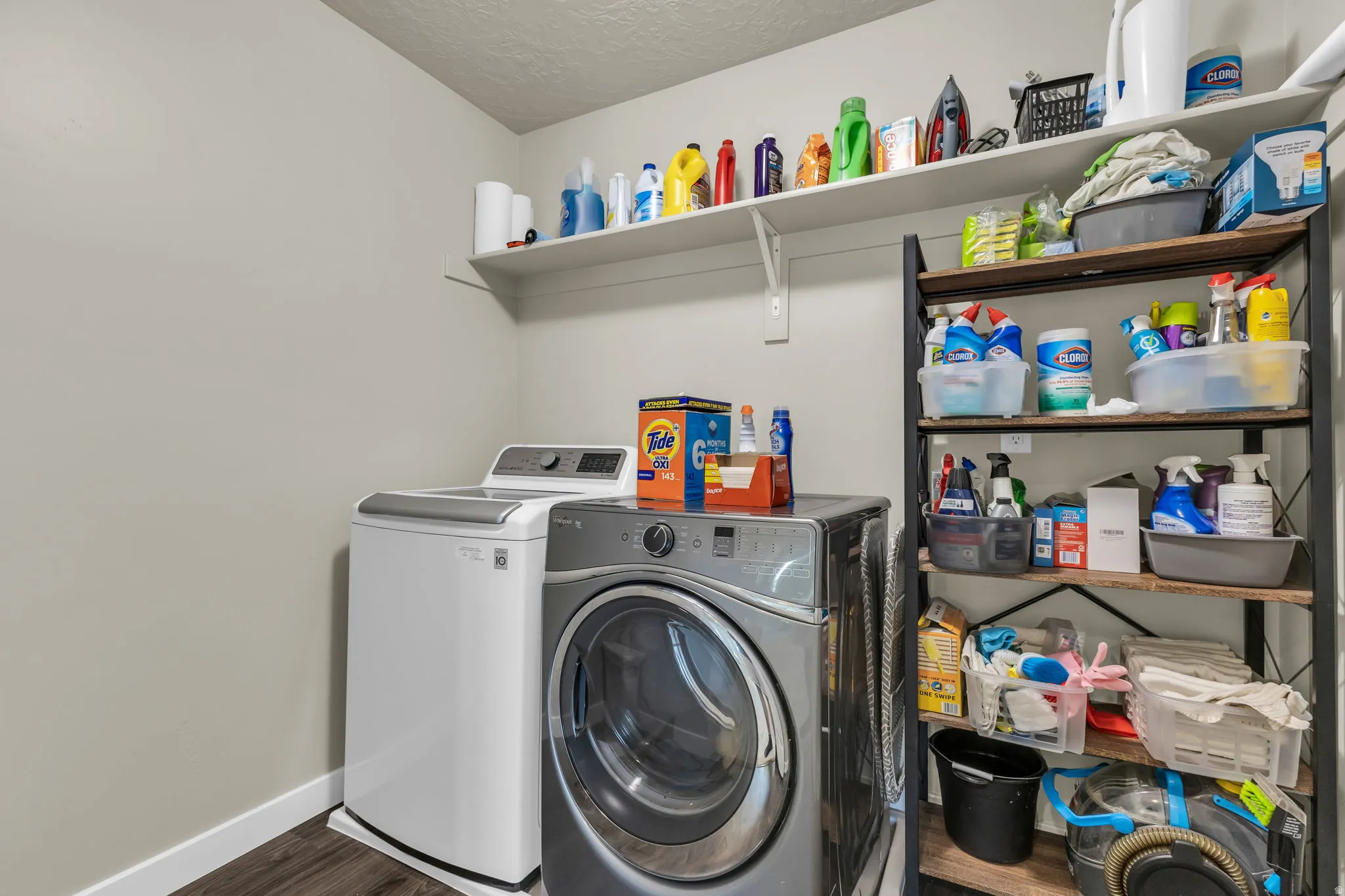 Laundry room featuring dark wood-style floors, independent washer and dryer, and a textured ceiling