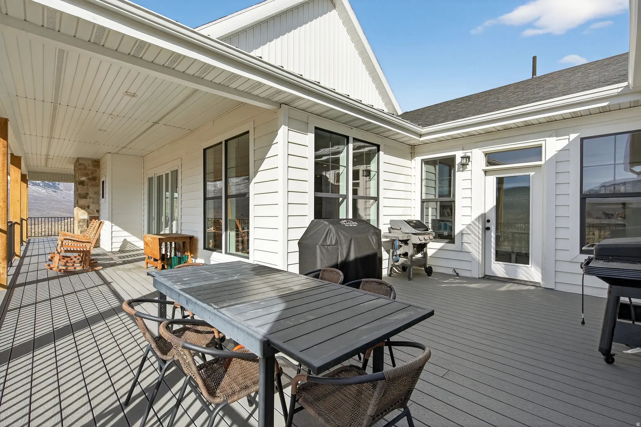 Wooden deck featuring grilling area and outdoor dining area