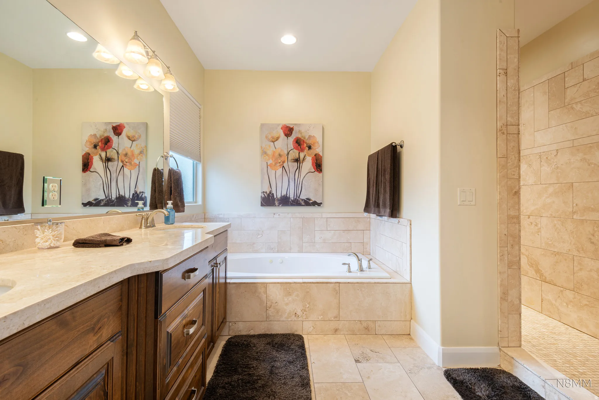 Bathroom featuring double vanity, a bath, a walk in shower, recessed lighting, and light tile patterned flooring