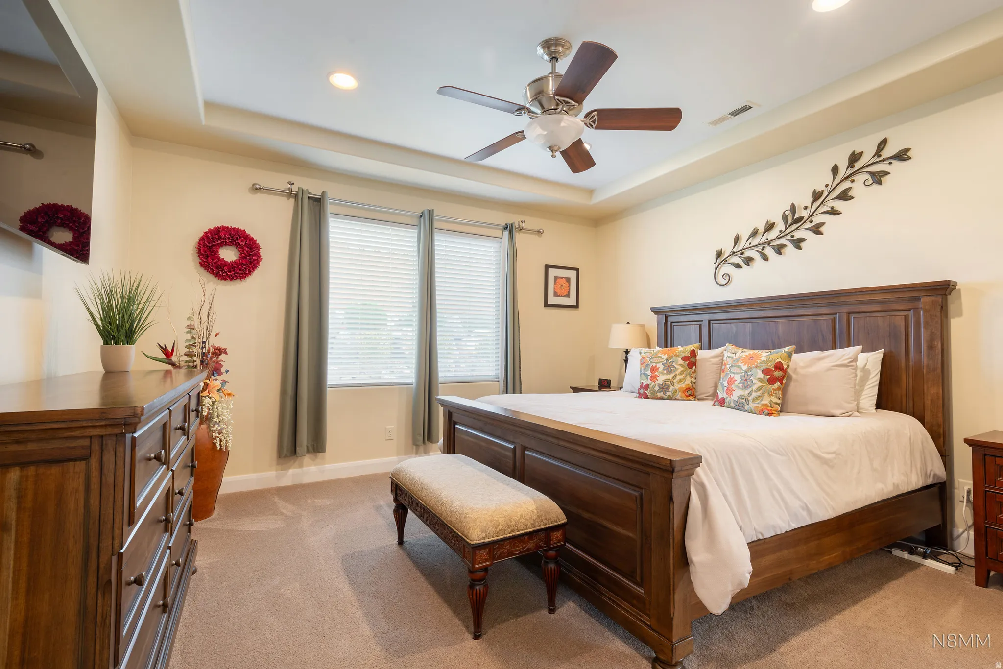 Bedroom featuring light colored carpet, a tray ceiling, a ceiling fan, and recessed lighting