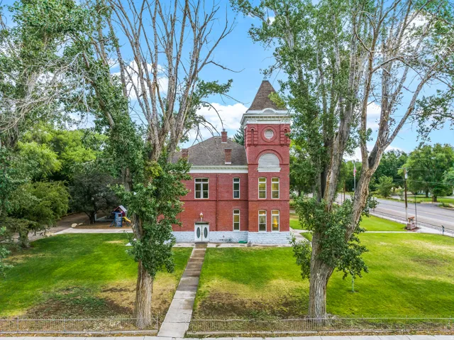 View of front facade with a front yard, brick siding, and a chimney
