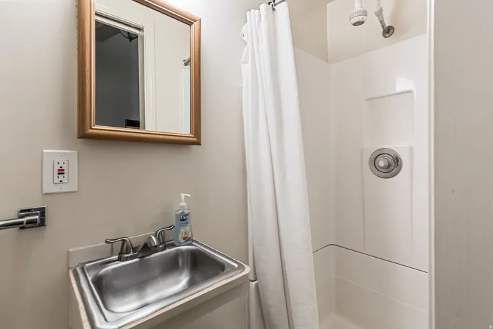 Bathroom featuring a sink and a shower stall