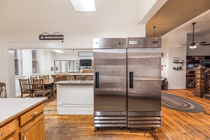 Kitchen featuring ceiling fan, light countertops, wood finish cabinetry, and stainless steel fridge