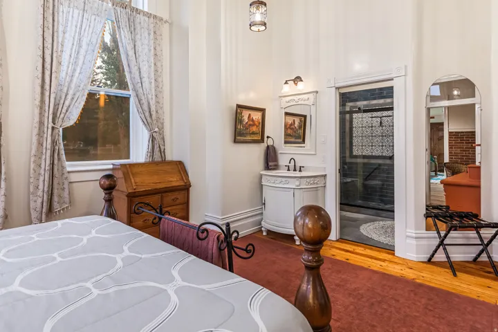 Bedroom with arched walkways and wood finished floors
