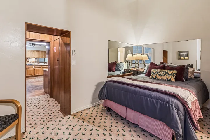 Bedroom featuring baseboards and a high ceiling