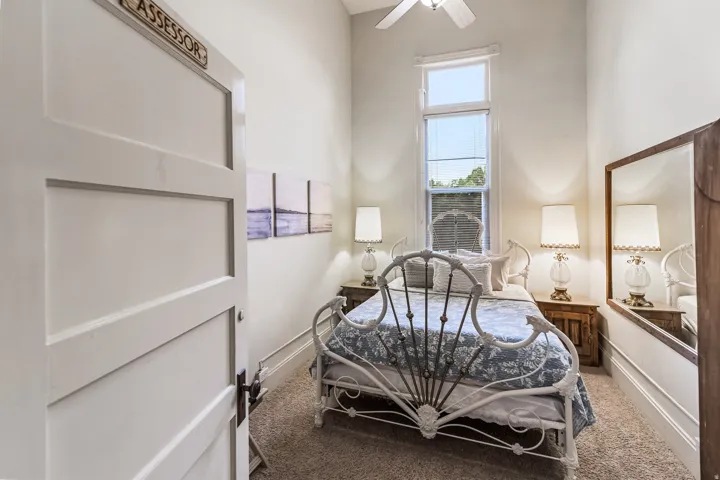 Bedroom featuring carpet floors, a high ceiling, and ceiling fan