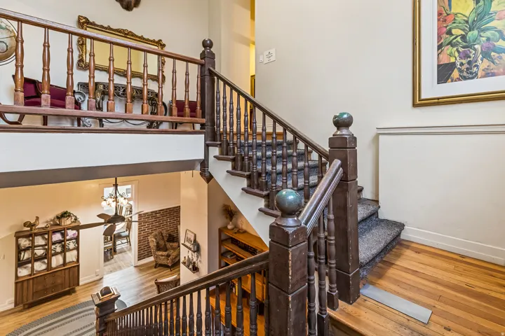 Stairway featuring hardwood / wood-style flooring, a high ceiling, and a chandelier