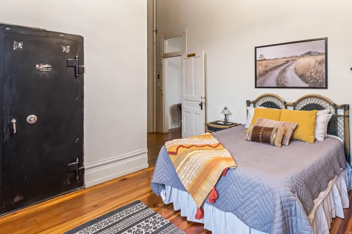 Bedroom with hardwood / wood-style flooring and baseboards