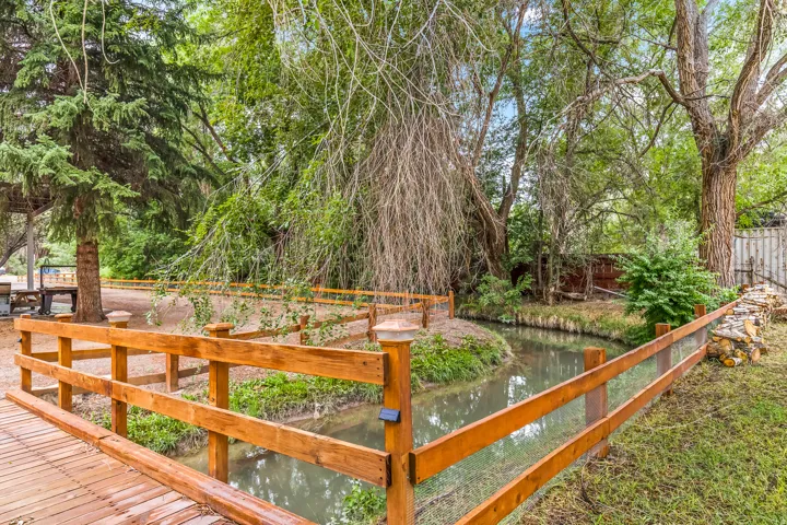Fenced yard featuring a water view and view of scattered trees