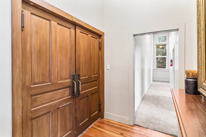 Hall with light wood-style flooring and baseboards