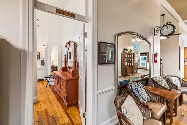 Hall featuring arched walkways and light wood-type flooring