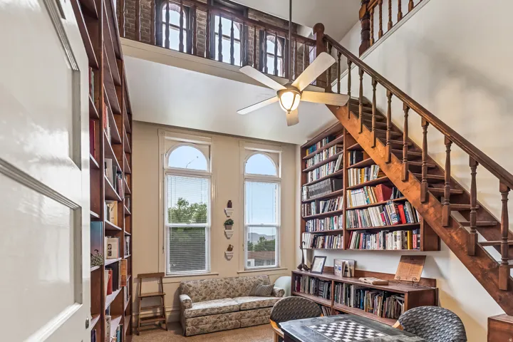 Sitting room with healthy amount of natural light, ceiling fan, carpet, and a high ceiling