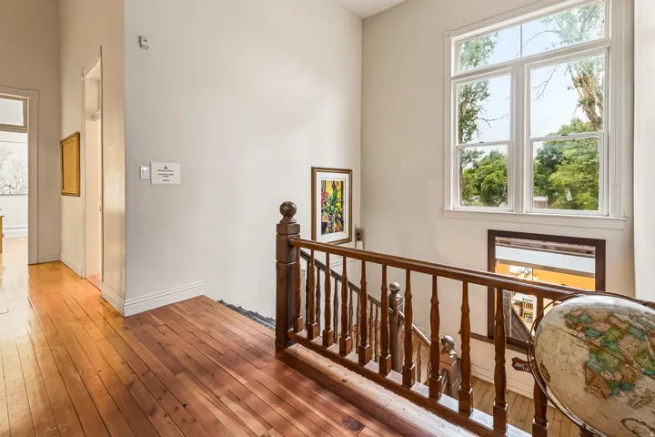 Corridor with an upstairs landing and hardwood / wood-style flooring