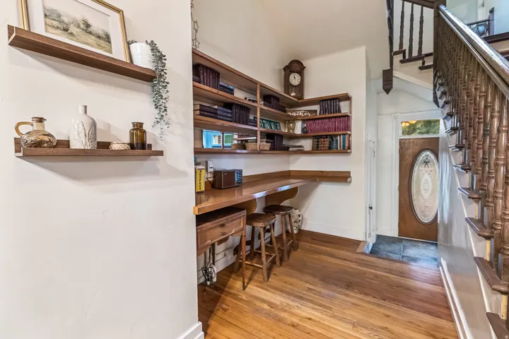 Office space featuring light wood-type flooring, built in study area, and vaulted ceiling