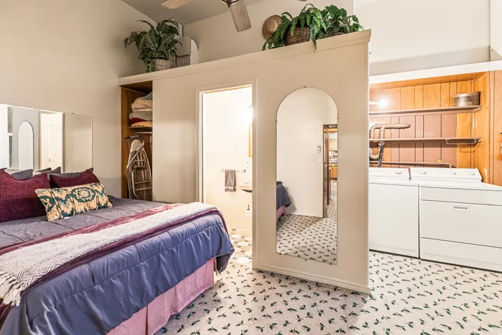 Bedroom featuring ensuite bath, washer and dryer, and arched walkways